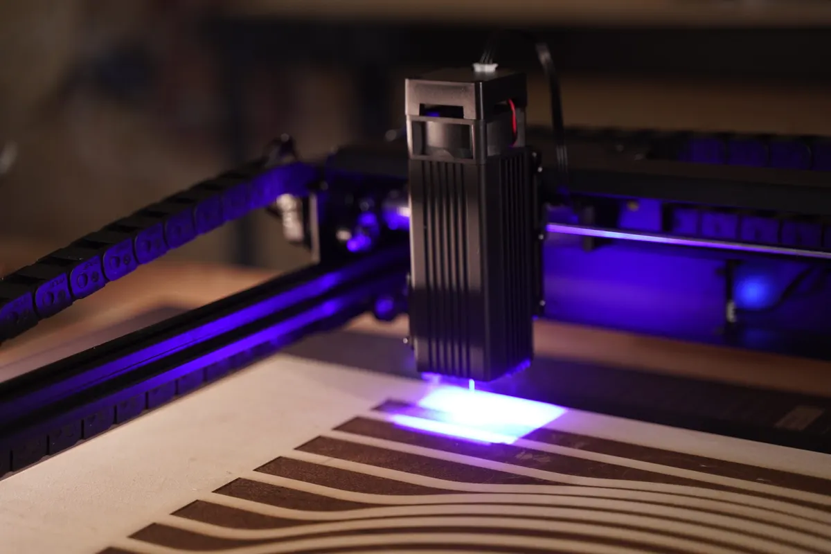 A diode laser cutting a detailed design from a wood sheet