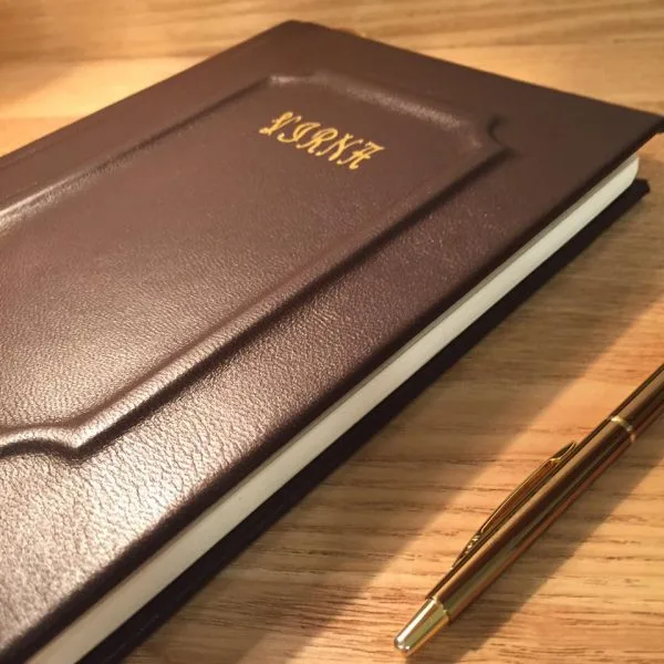 A finished brown leather notebook on a wooden table